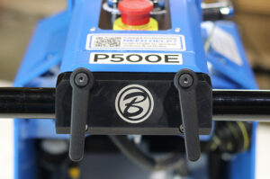 Close-up of a blue P500E hydraulic lift with two black handles and a circular logo on the front panel.
